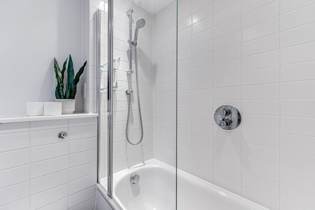 A pristine bathroom suite featuring a sleek whi...