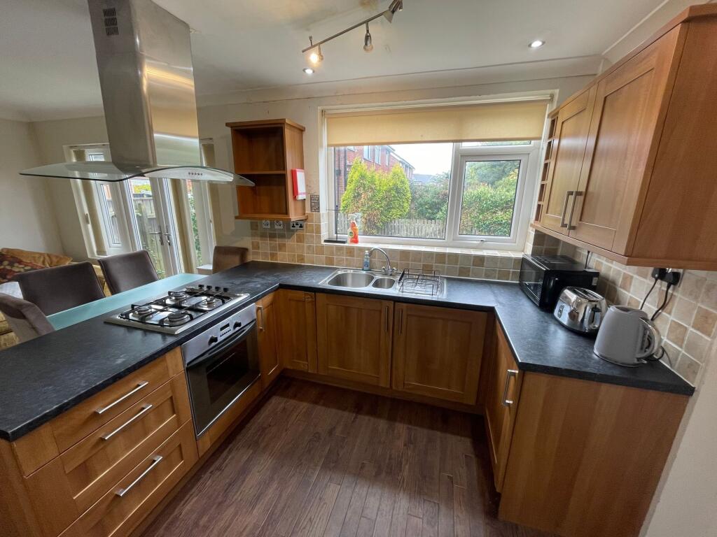Bright and well-equipped kitchen featuring wood...