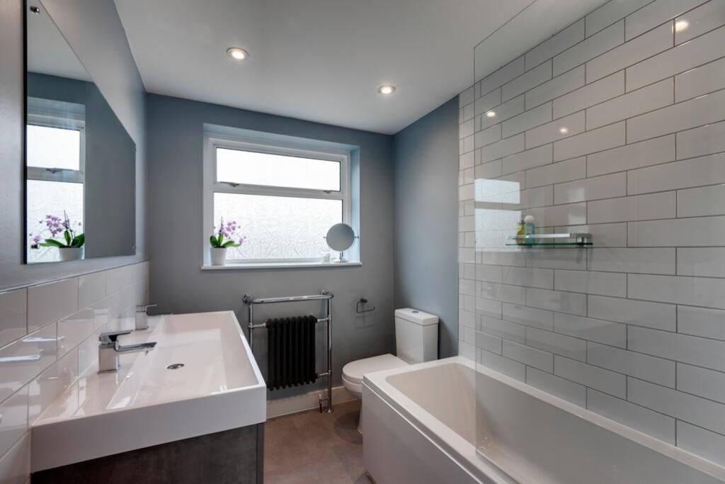 A modern, clean bathroom featuring a large bath...