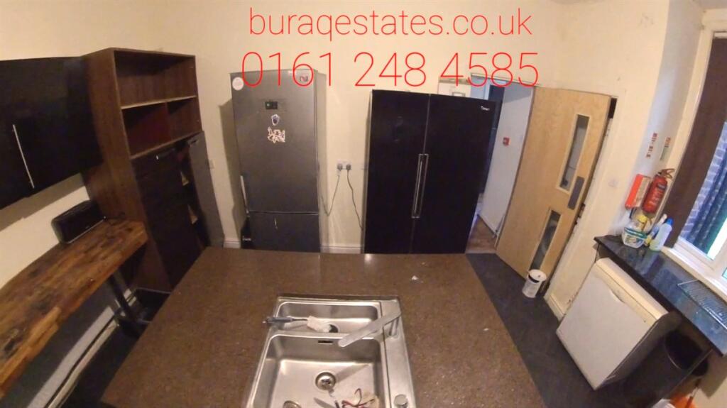 Modern kitchen featuring sleek black cabinets, ...