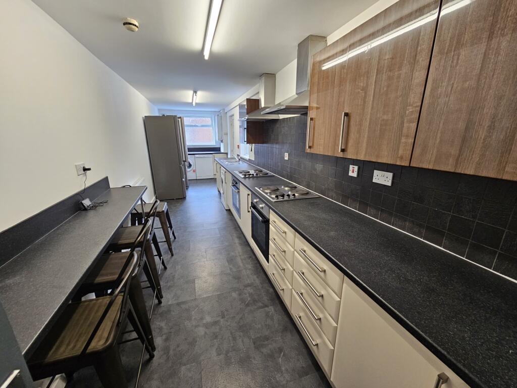 A modern, long galley kitchen with ample counte...