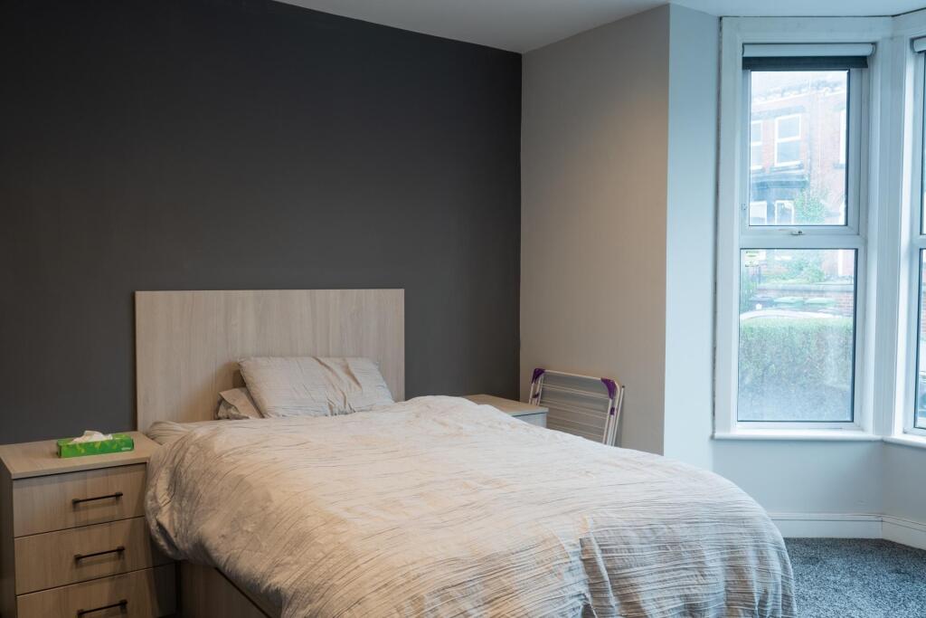 A bright, inviting bedroom featuring a comforta...
