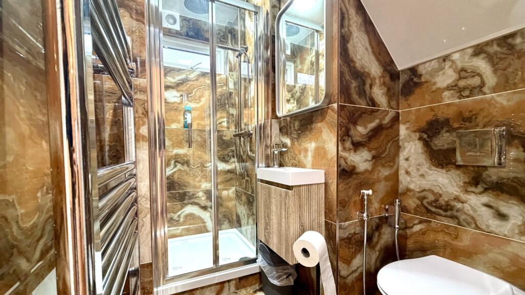 Stylish ensuite bathroom featuring a glass show...
