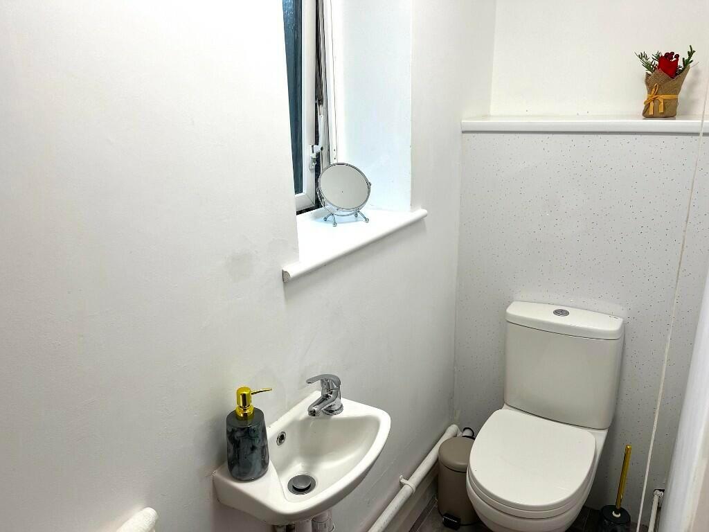 A clean and tidy small toilet room featuring a ...