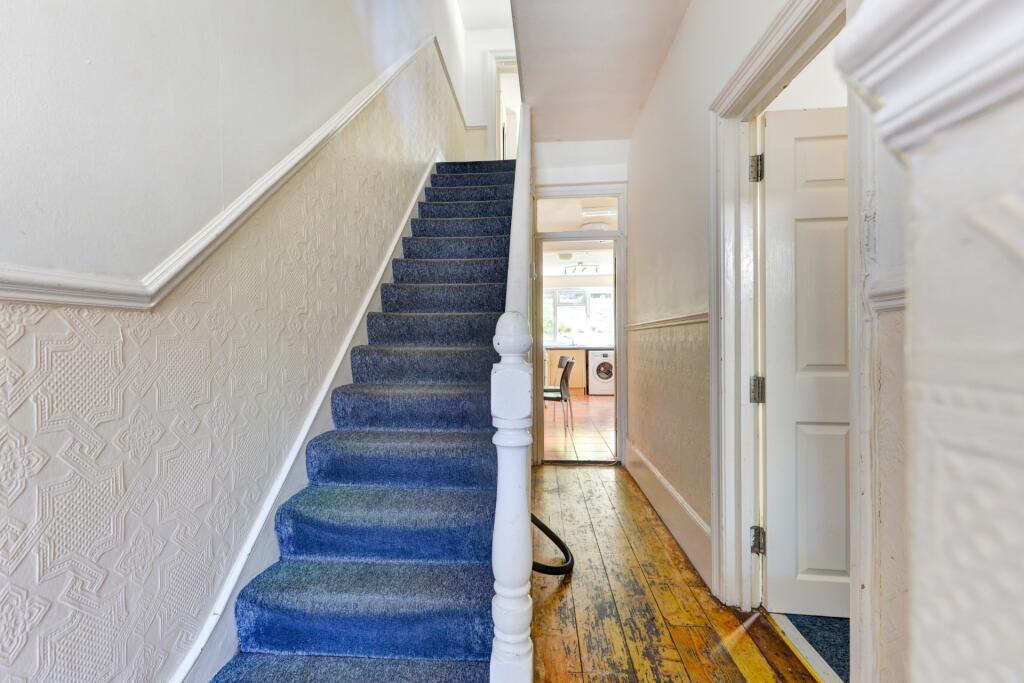 Bright and inviting hallway featuring a deep bl...