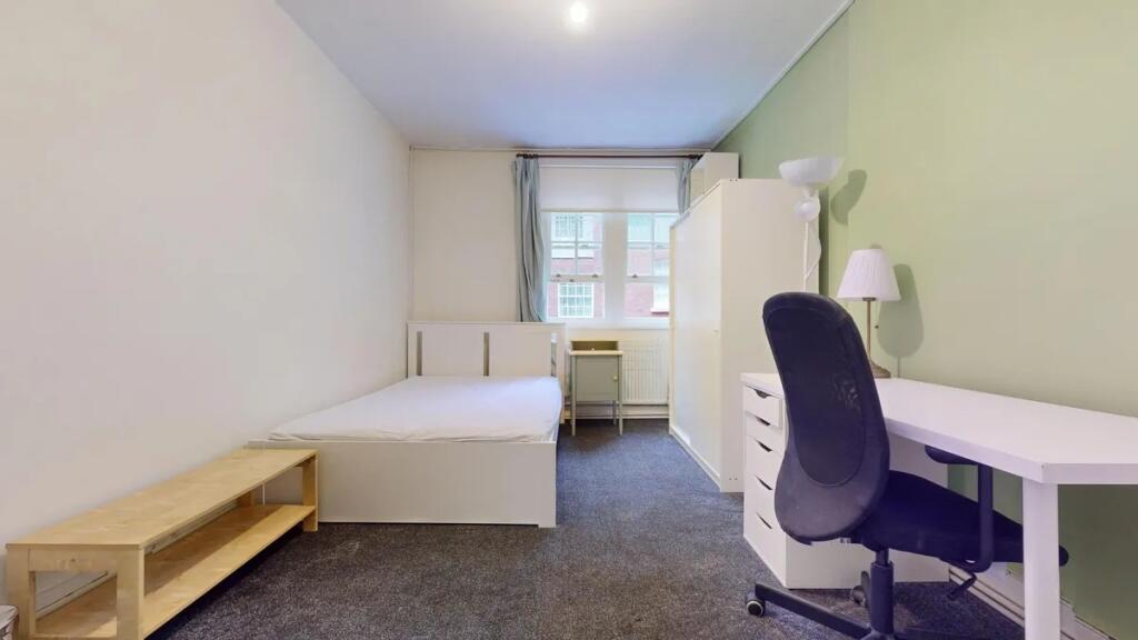 A neat and well-lit single bedroom featuring a ...