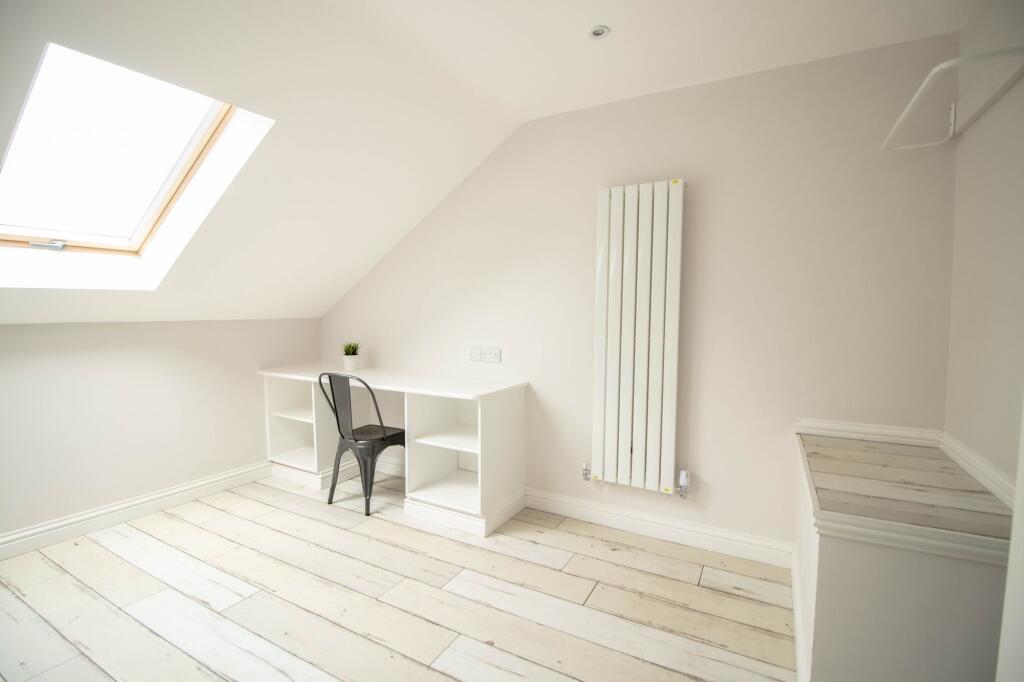 Bright and airy bedroom featuring a large skyli...