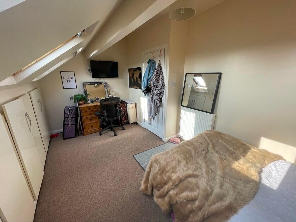 Cozy and bright single bedroom featuring sloped...