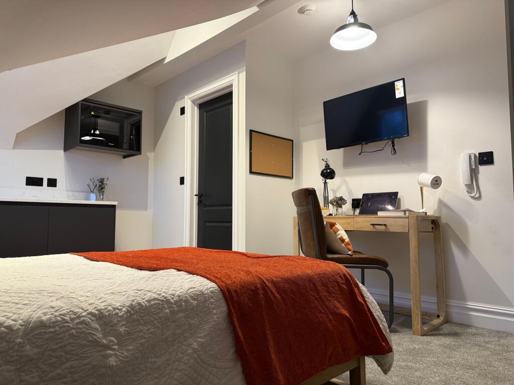 A modern and tidy double bedroom featuring a co...