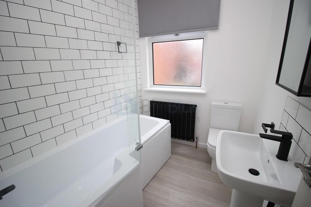 Bright and modern bathroom featuring a white ba...