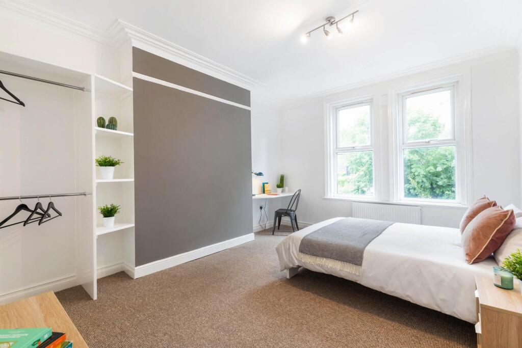 Bright and spacious master bedroom with large w...