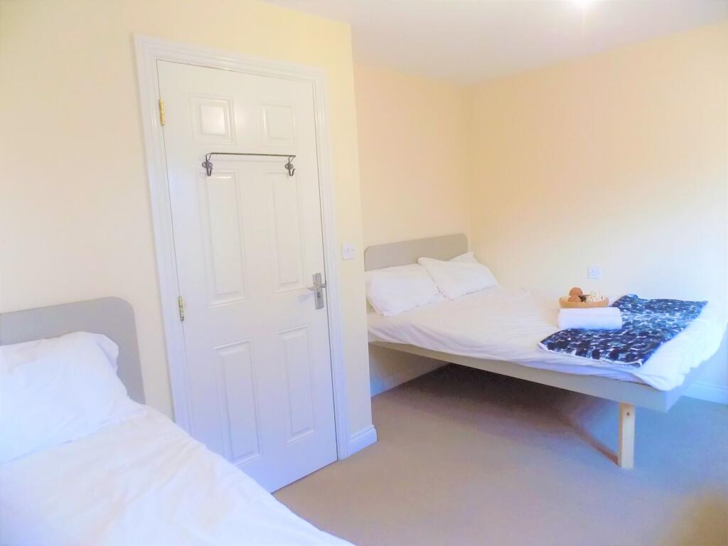 A bright and tidy double bedroom featuring two ...