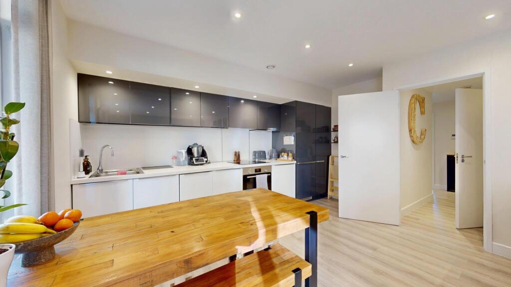 Modern, well-lit kitchen with ample counter spa...