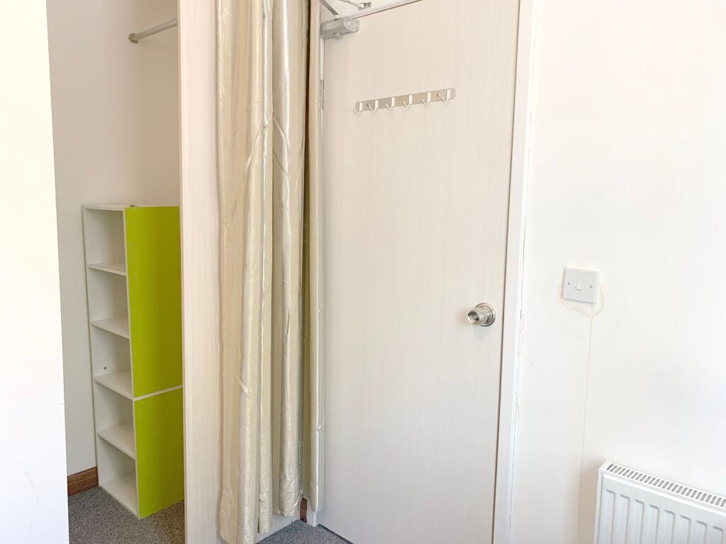 Bright and tidy hallway featuring a white door ...