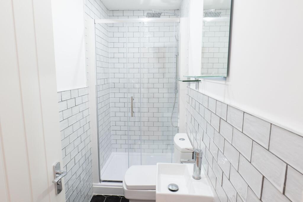 A modern bathroom featuring white subway tiles ...