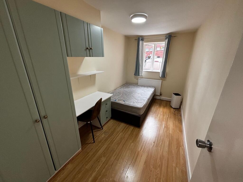 A cozy student bedroom featuring a single bed a...