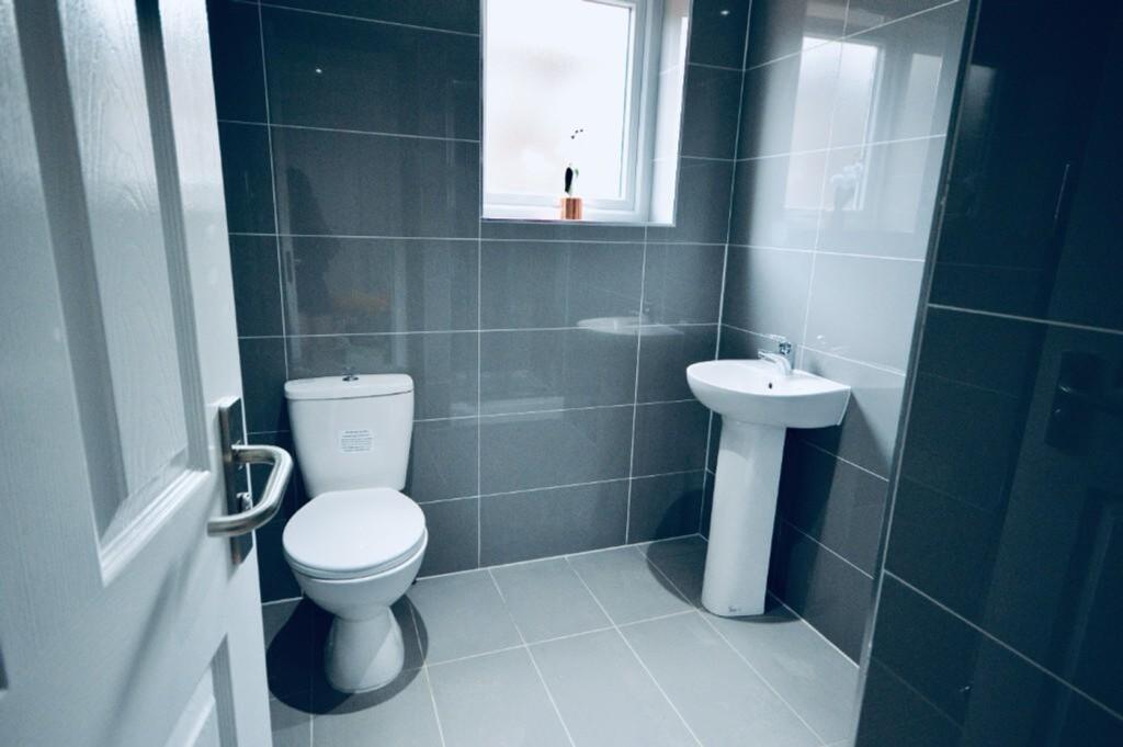 A modern and clean bathroom featuring sleek til...