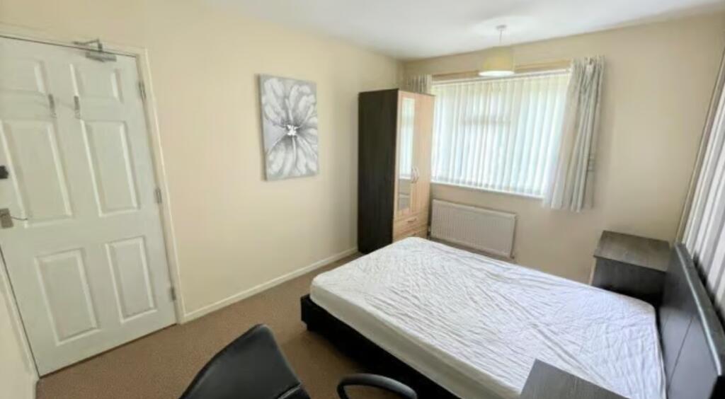 Bright and tidy double bedroom featuring a comf...