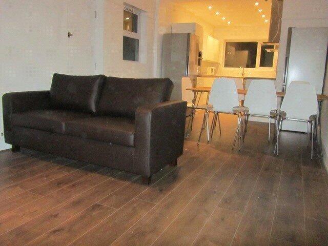 A modern living room with a dark brown sofa and...