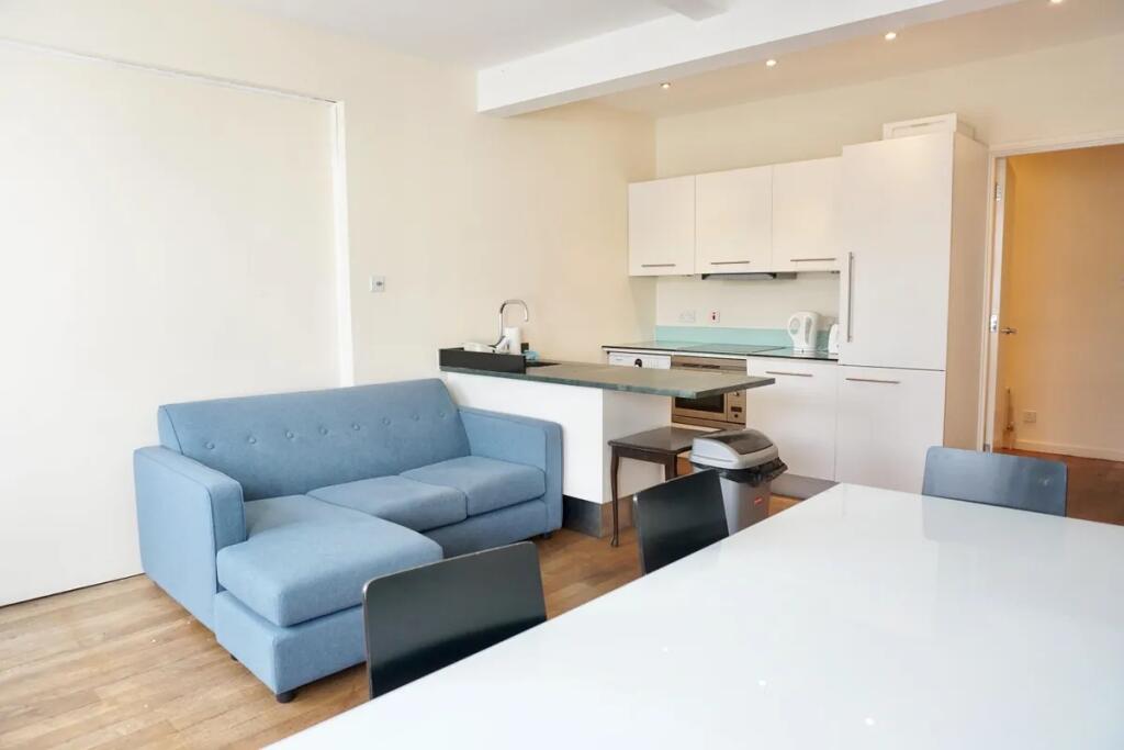 Bright and modern living room featuring a comfo...