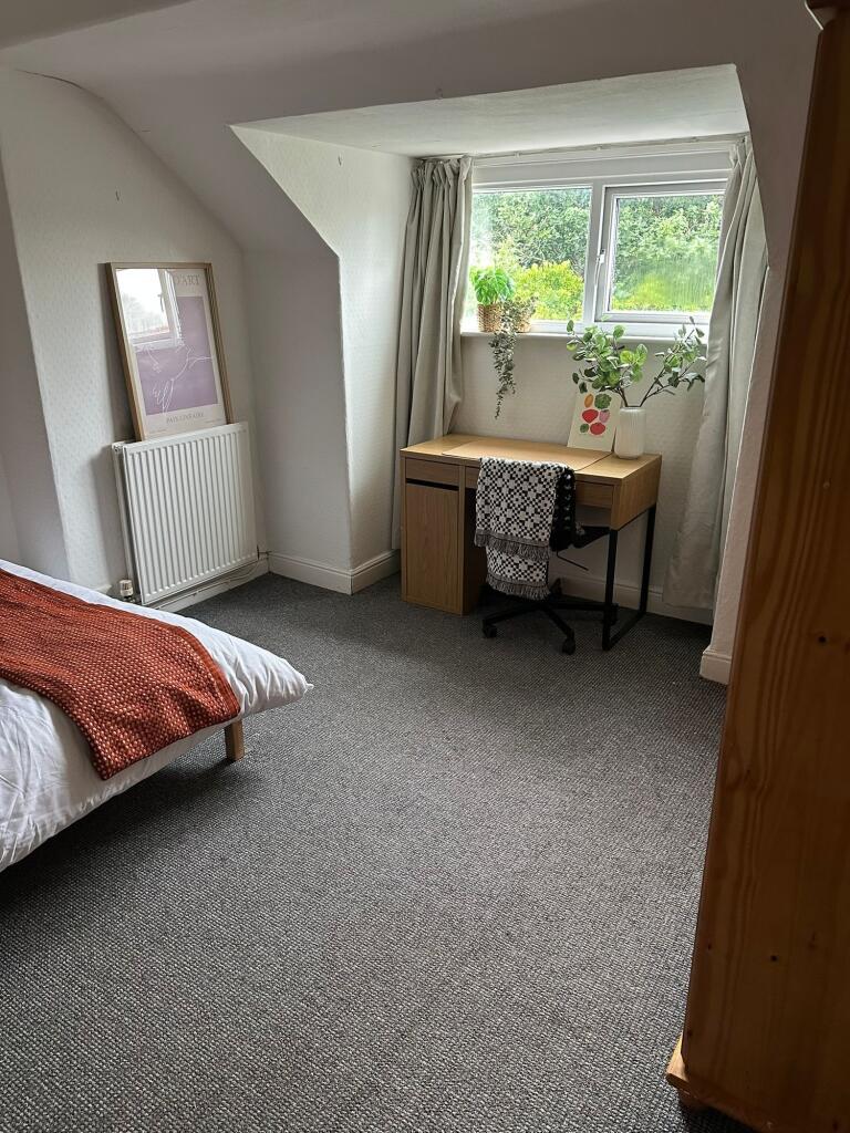 A cozy, well-maintained single bedroom with a c...