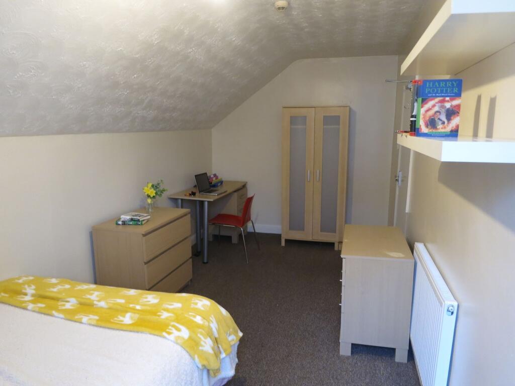 A cozy student accommodation room featuring a b...