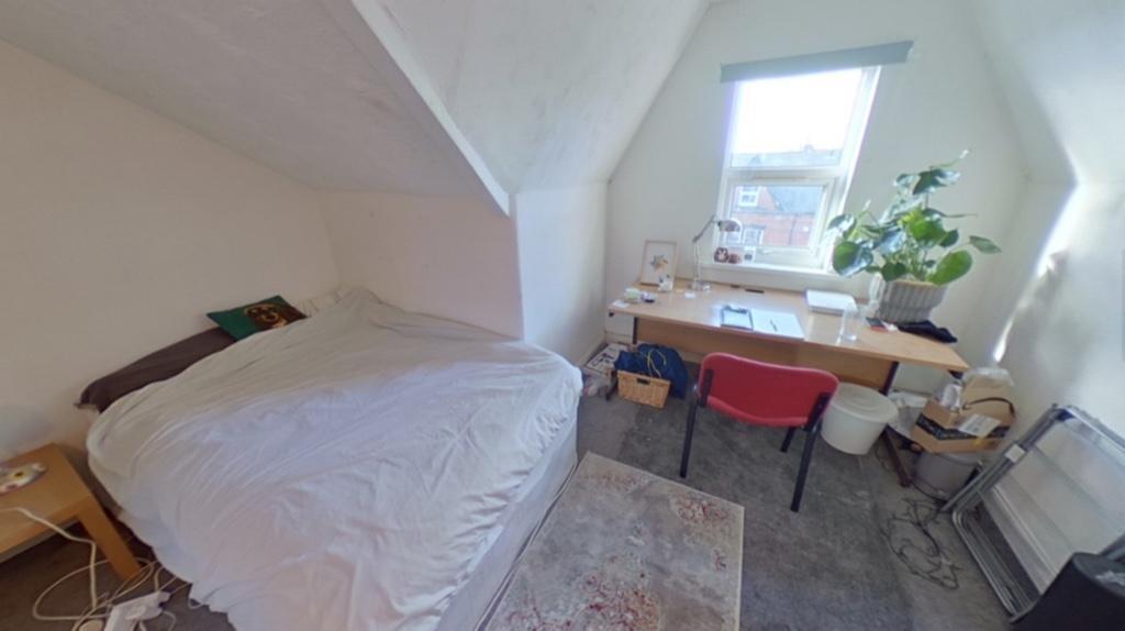 Bright and cozy master bedroom featuring a comf...