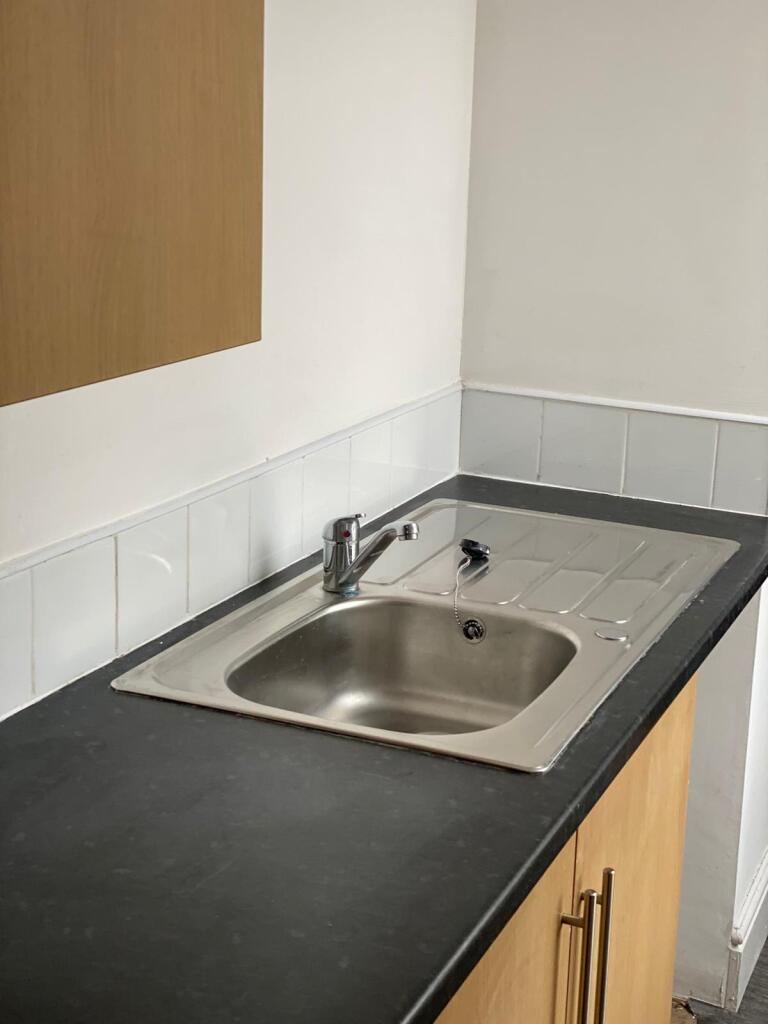 Compact kitchen space featuring a clean stainle...