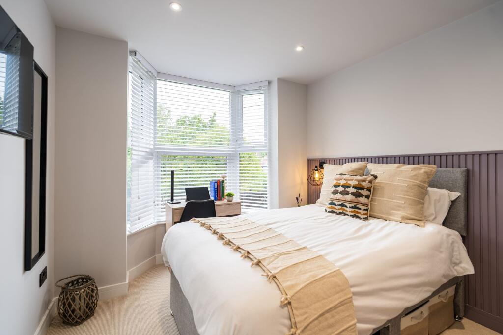 A bright, spacious double bedroom featuring a l...
