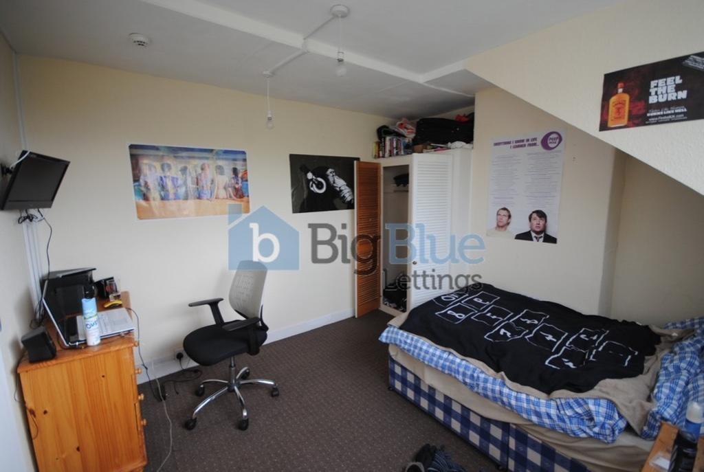 A cozy single bedroom featuring a neatly made s...