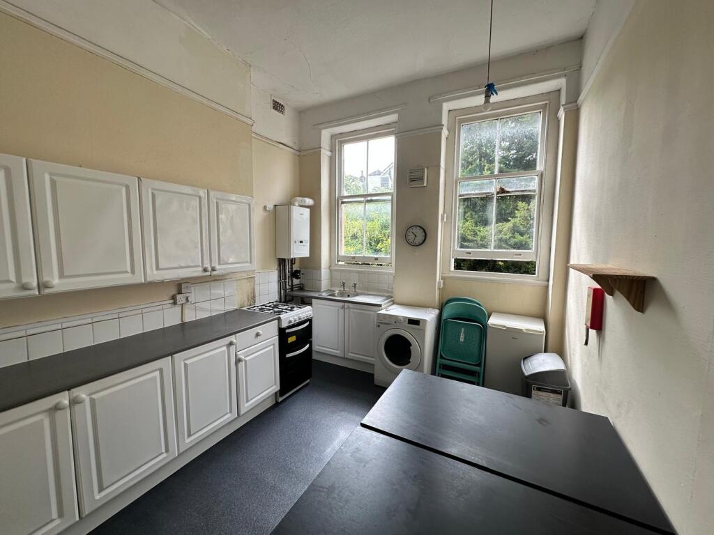A spacious and functional kitchenette with ampl...