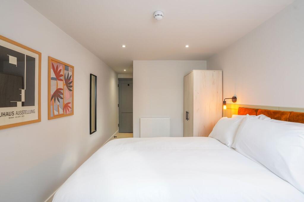 A modern and clean double bedroom featuring a l...