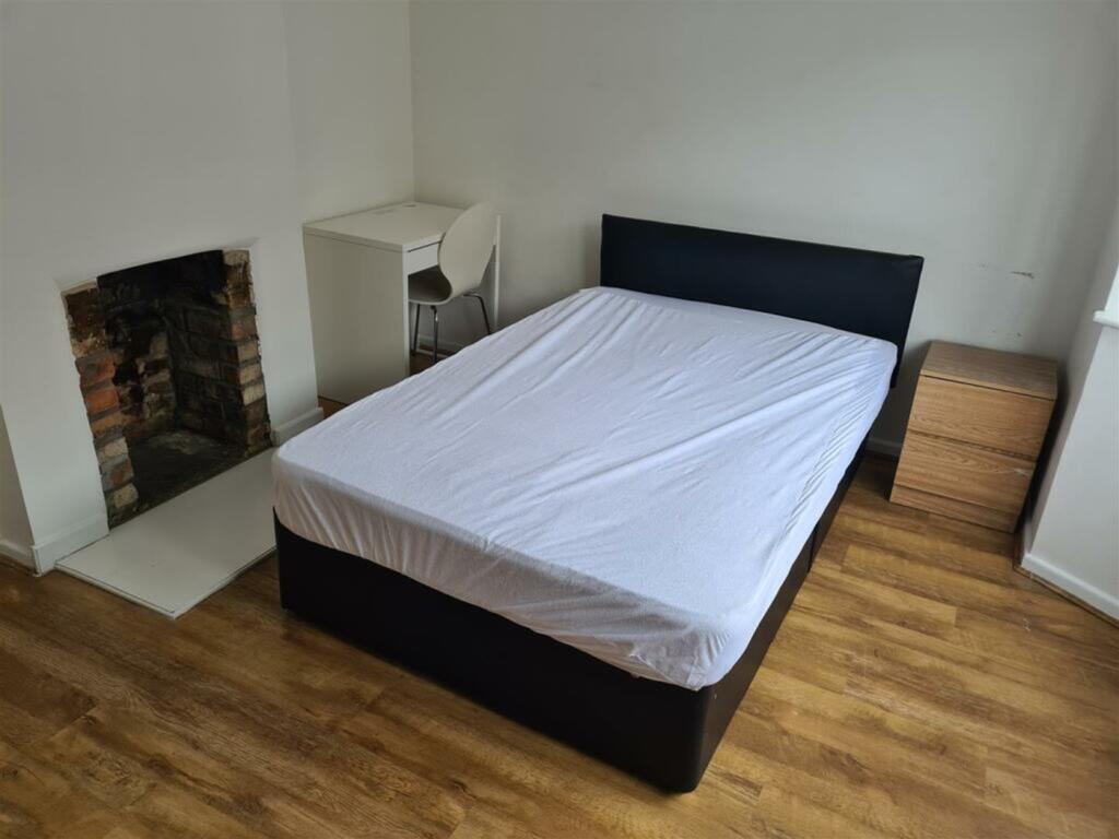 A spacious and inviting double bedroom with a c...