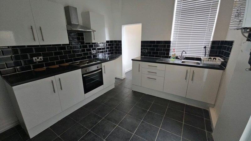 Modern kitchen with sleek black countertops and...