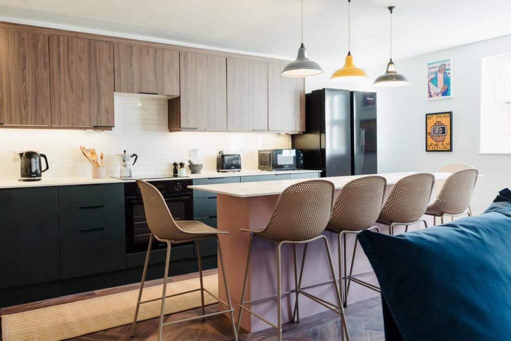 A modern, well-lit living room featuring a comf...