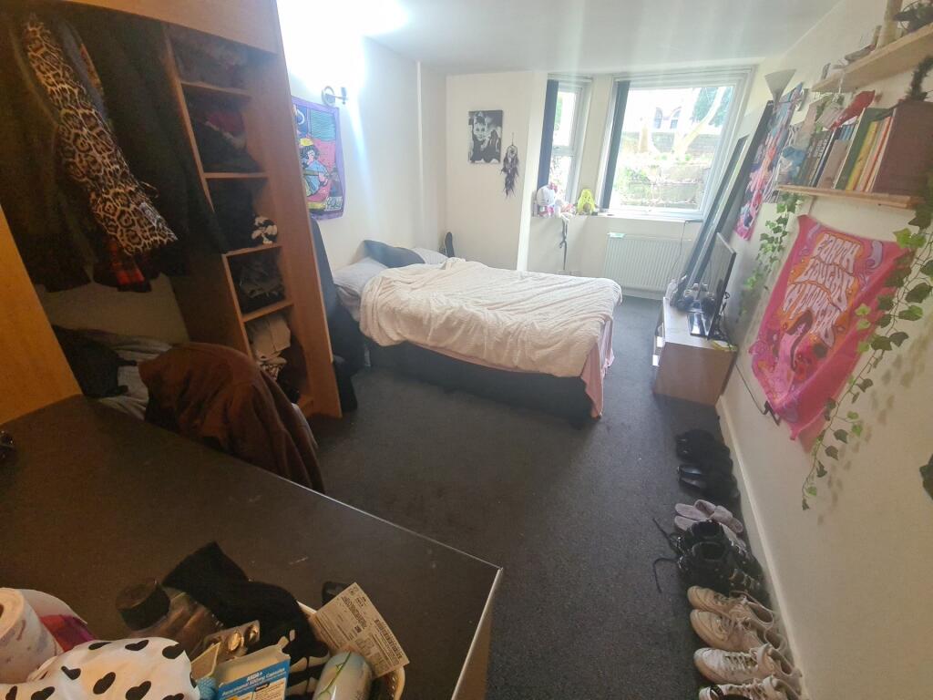 A cozy bedroom featuring a single bed near the ...