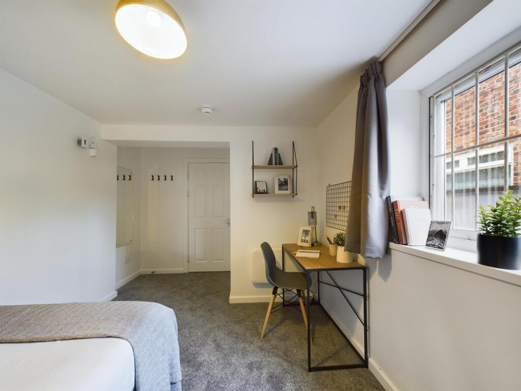 A spacious and tidy double bedroom featuring a ...