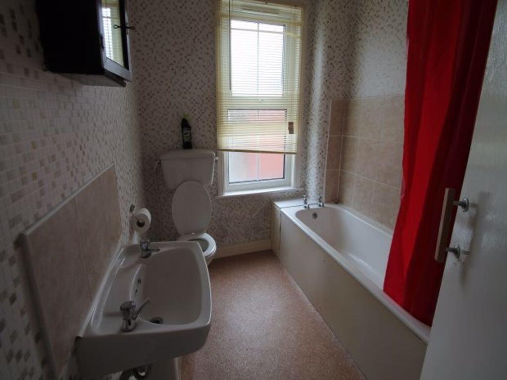 Bright and tidy bathroom featuring a bathtub an...