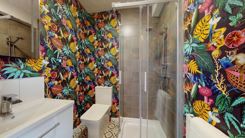 This vibrant and modern bathroom features a sty...
