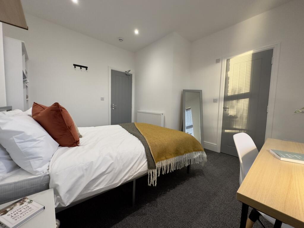 A bright and inviting double bedroom with moder...