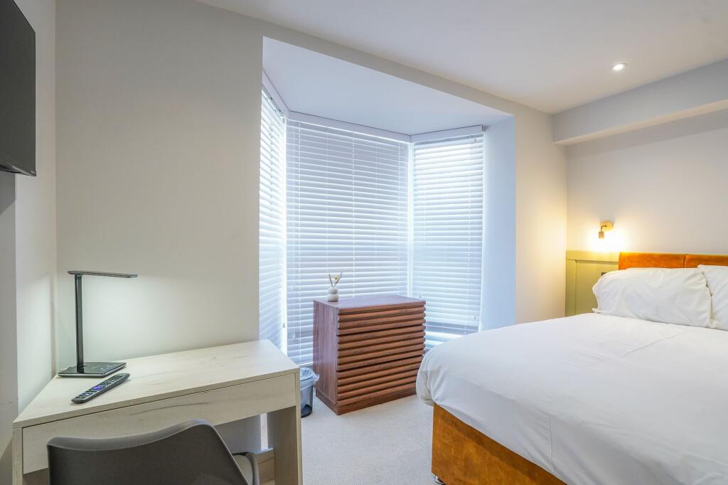 Bright and stylish master bedroom featuring a c...