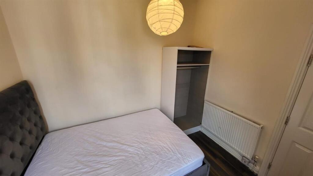 A small, tidy toilet room with basic fixtures, ...