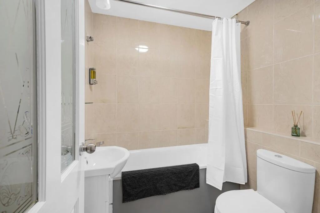 A clean and modern bathroom suite featuring bei...