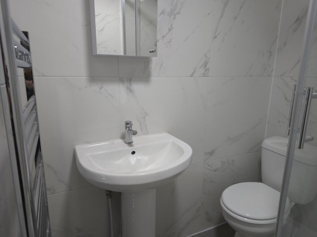Bright, modern bathroom with a pedestal sink, m...