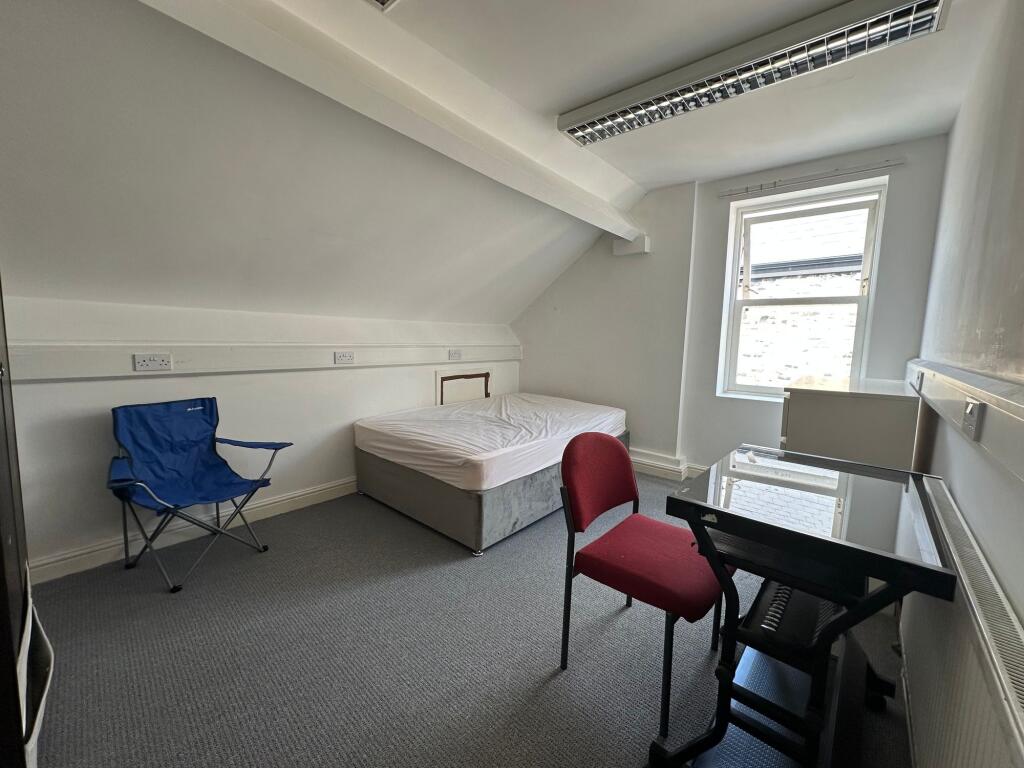 Bright single bedroom with a comfortable bed, a...