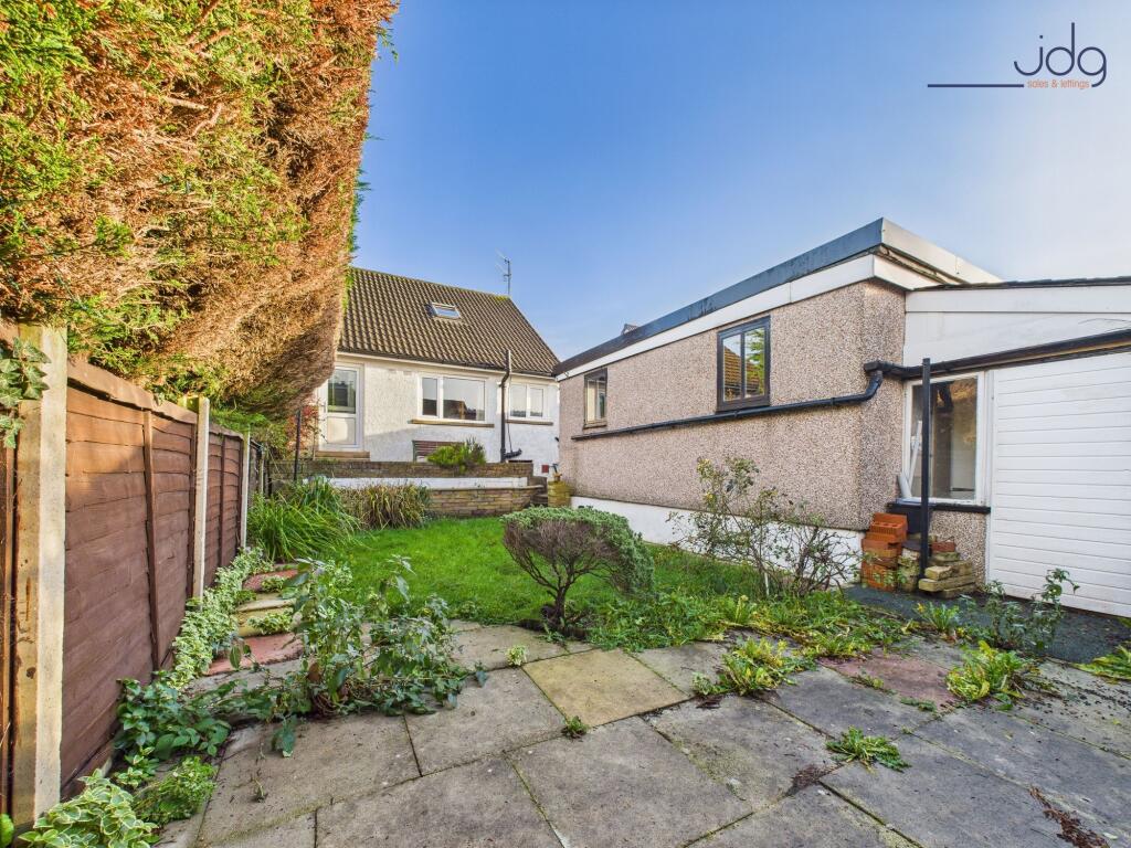 A mixture of flag and lawn garden with garage and workshop access