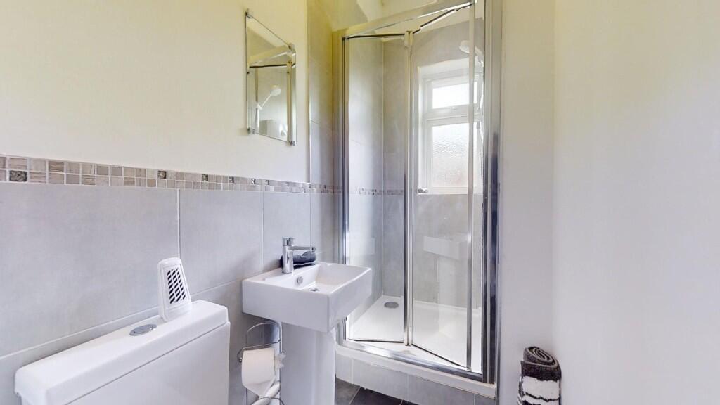 Bright and clean bathroom suite featuring a mod...
