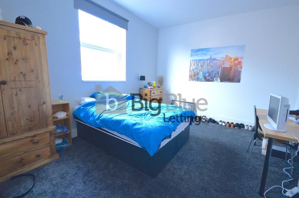 A bright double bedroom featuring a comfortable...