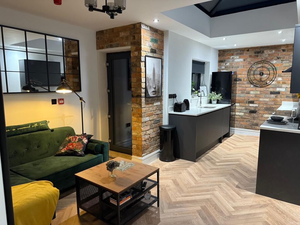 A stylish and contemporary living room featurin...