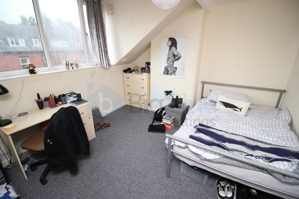 A cozy single bedroom with a large window provi...